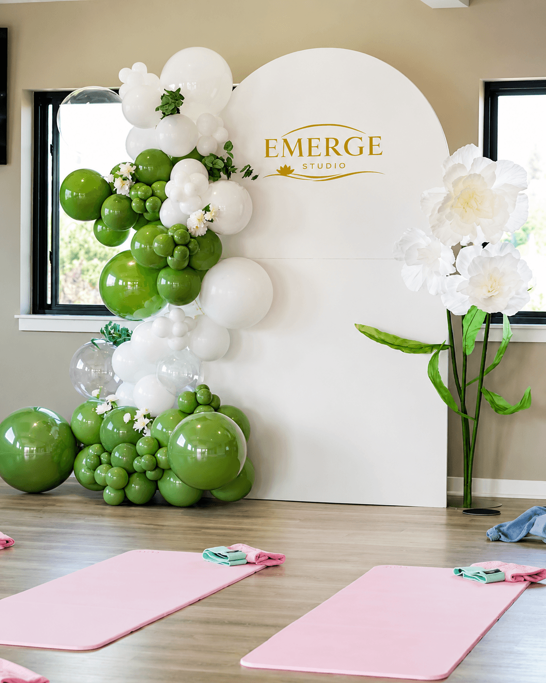 Green and white floral balloon backdrop installed for the Emerge Studio brand event