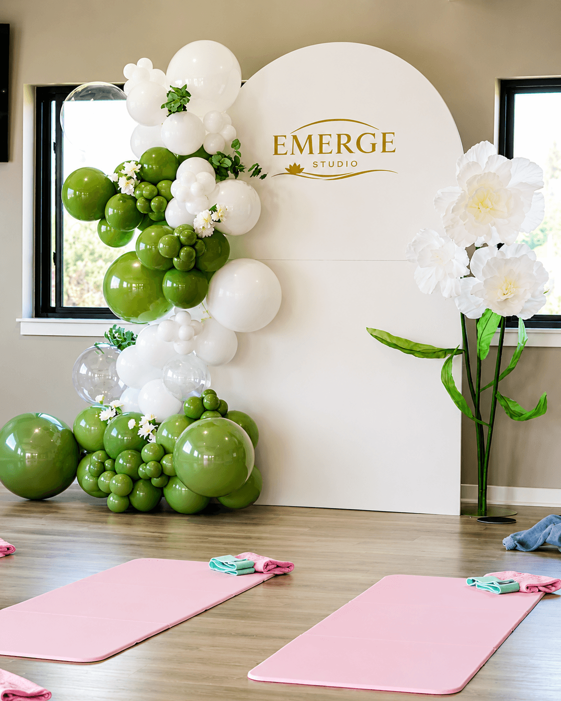 Green floral balloon backdrop styled for the Emerge Studio brand activation event