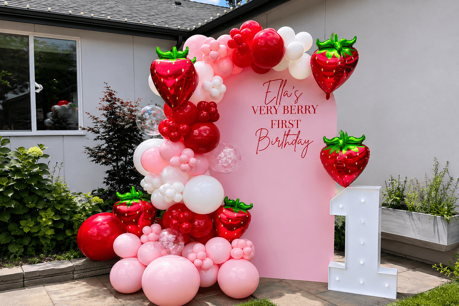 Pink and red balloon garland arch with giant strawberry balloons, custom first birthday backdrop in Marysville, WA