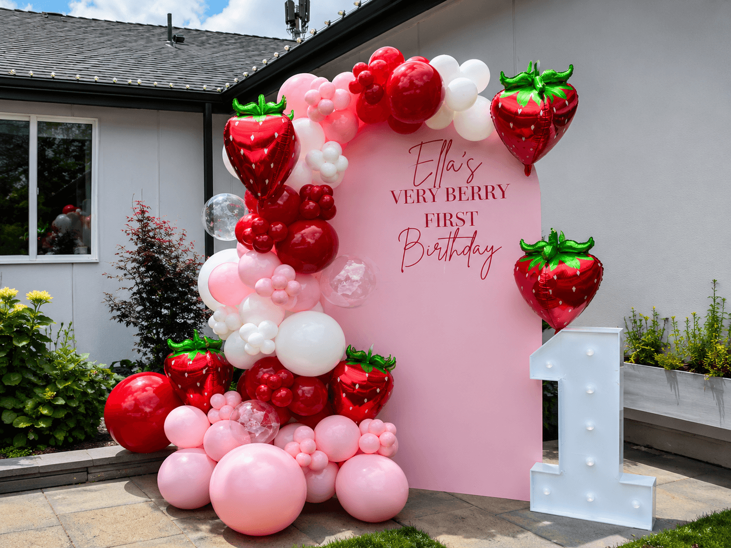 Balloon garland backdrop being custom built on-site for a client celebration