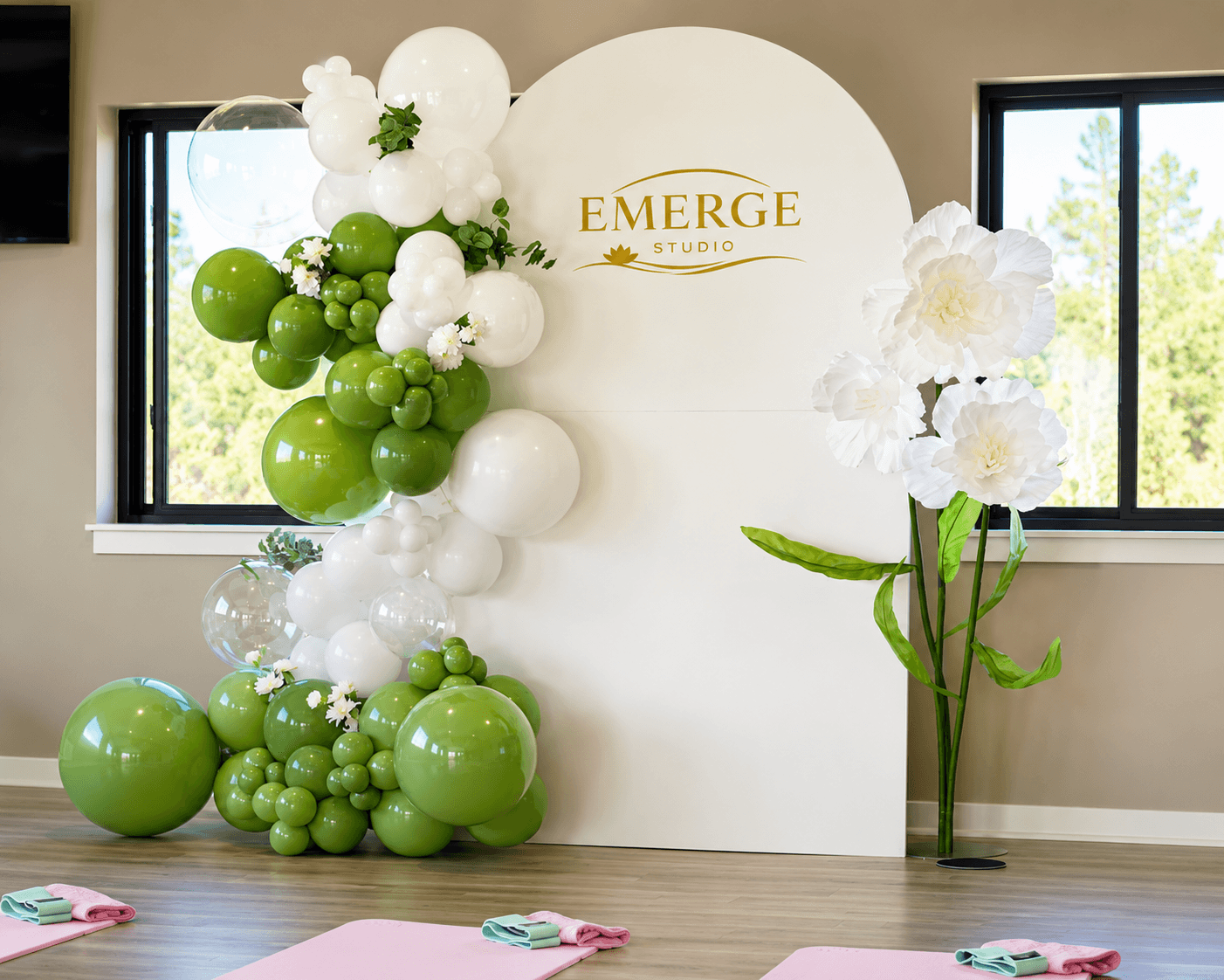 Balloon garland being hand-styled piece by piece into an arch backdrop